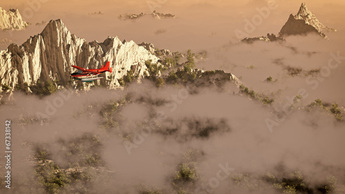Red airplane flying over snow mountains with pine trees in the c