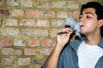 Young man enjoying a satisfying e-cigarette