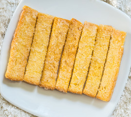 Baked bread buttered and sprinkled with sugar granules