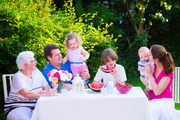Big family eating fruit in the garden
