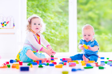 Brother and sister playing with colorful blocks