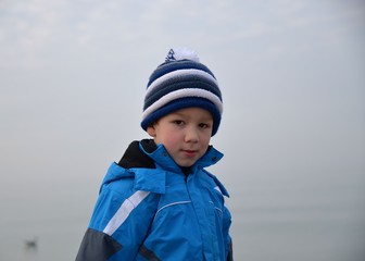 Portrait eines Kindes in Winterkleidung am Meer