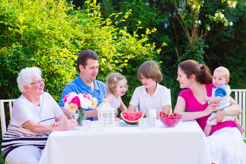 Cute family eating fruit in the garden