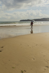 Hombre con paraguas paseando por la orilla de la playa