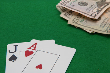 Blackjack hand with Dollar notes on green background