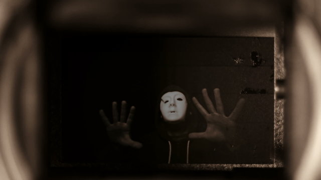 Mysterious horror person reflected inside a camera.