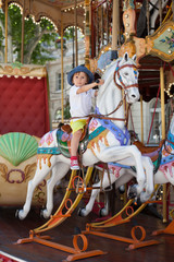Fototapeta na wymiar Cute kid, riding on a carousel