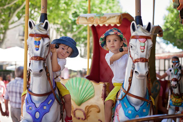 Cute kids, riding on a carousel