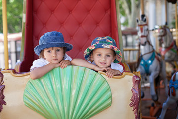 Cute kids, riding on a carousel