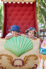 Cute kids, riding on a carousel