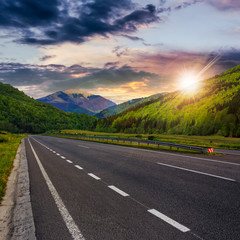 asphalt road in mountains at sunset