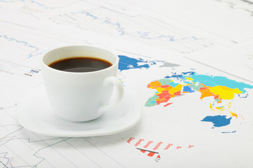 Cup of coffee over world map - studio shot