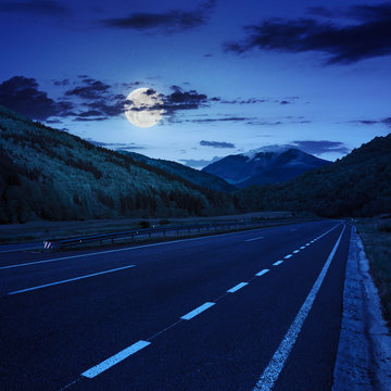 asphalt road in mountains at night