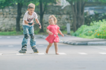 young happy boy faving fun on roller scates on natural backgroun