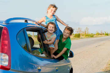 Fototapeta na wymiar three happy kids in car, family trip, summer vacation travel