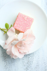 A fresh cake with a rose bud, close cup