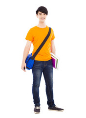 smiling young student standing and  holding books