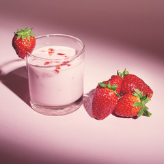 Strawberry yogurt with fresh strawberries on pink background
