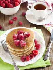 Stack of pancakes with fresh raspberries.