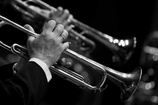 Hands of the man playing the trumpet in black and white