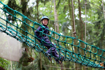 Happy boy enjoying a climbing adventure in activity park