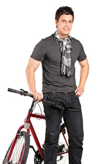 Fototapeta na wymiar Fashionable young man standing by a bicycle