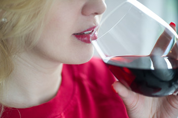 Woman drinking red wine with red lips and wineglass