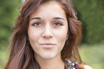 Closeup portrait of beautiful young woman with freckles.