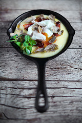 Polenta porridge with poached egg, fried prosciutto and truffles