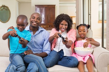 Happy family relaxing on the couch playing video games