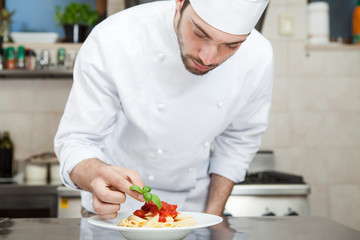Male chef completing pasta. - 67365199