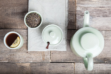 Tea set with tea crop, croissants, teapot and mug.