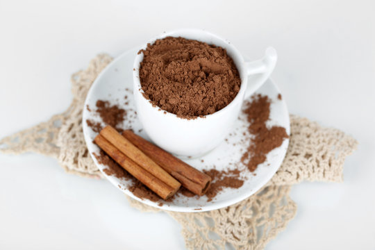 Cocoa powder in cup with saucer on napkin isolated on white