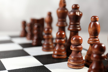 Chess board with chess pieces on grey background