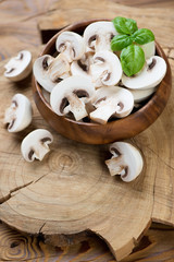Fresh sliced champignons with green basil leaves, studio shot