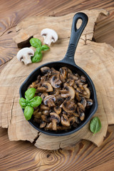 Cast-iron frying pan with roasted champignons, high angle view