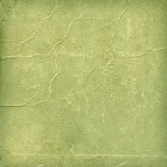 Fototapeta premium Green paper texture with aged creases features a weathered olive sage surface, offering a vintage distressed backdrop for scrapbooking, artistic layouts, and graphic design