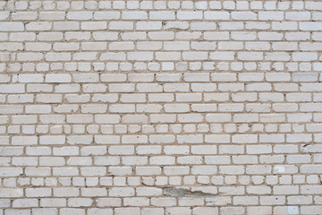Cracked white grunge brick wall textured background stained old