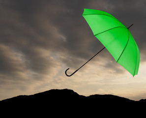 Bad weather background. Green umbrella over stormy sky.