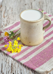 Obraz na płótnie Canvas Fresh milk in ceramic mug and flowers