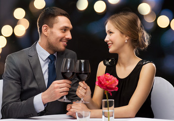 young couple with glasses of wine at restaurant