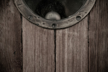 Close-up of a wooden boat closed porthole