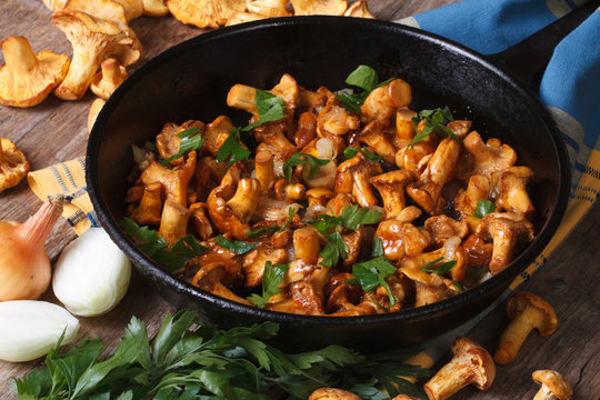 fried chanterelle mushrooms with onion and parsley in a pan
