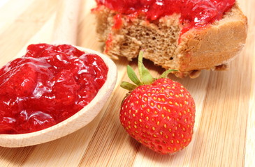 Fresh fruits and strawberry jam on wooden cutting board