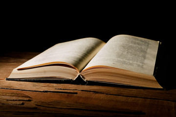 Old book on table on black background