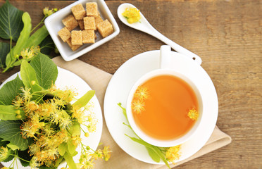 Tasty herbal tea with linden flowers on wooden table