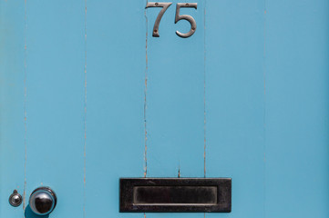 Door number 75 close-up with letter box
