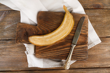 Halved ripe banana on wooden background © Africa Studio