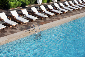 Lounge sunbeds near swimming pool