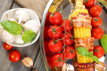 Grilled bacon wrapped corn on table, close-up